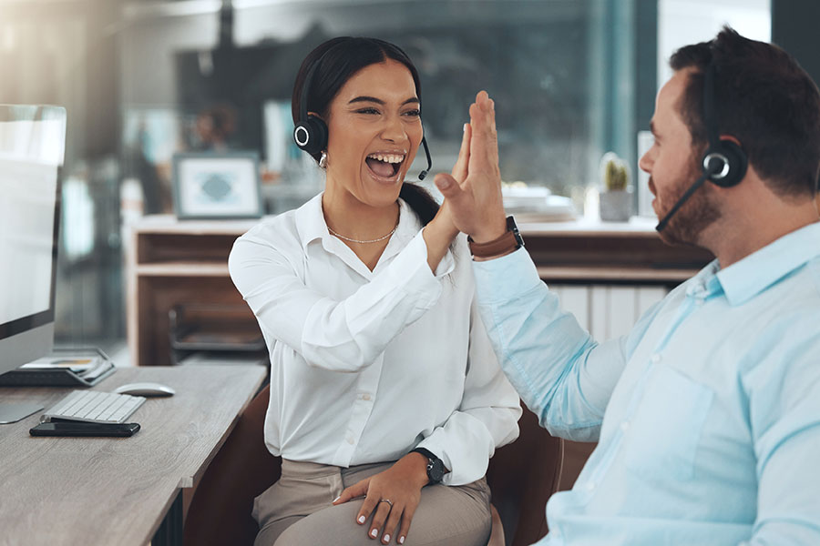 Answering services team high-fiving at work